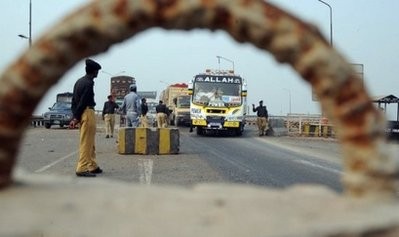 Pakistani policemen search vehicles on a link road in Lahore.