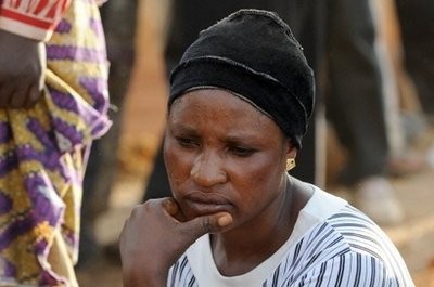 A woman reflects as women and children, killed during religious clashes in central Nigeria, are buried in a mass grave on March 8.