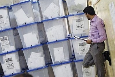 A member of the Independent High Electoral Commission counts ballot boxes stored at the group's headquarters in Baghdad