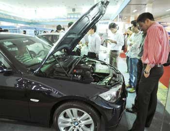 Customers inspect cars at an auto shop in Vietnam. Despite a decline in sales, many car importers say they will have to raise prices to make up for higher VAT and registration fees. (Photo: Dat Viet)