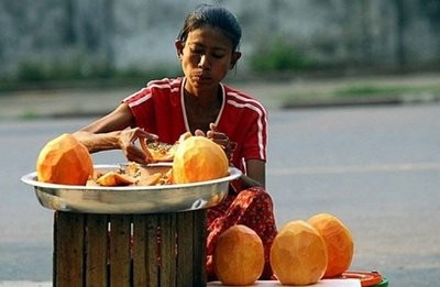 A street vendor prepares papaya for her daily customers in Yangon, Myanma.