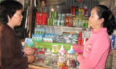 Hoang Thi Xuyen (L), chairwoman of Tam Thon Hiep Commune Women’s Union, visits a local resident who opened her own store thanks to a loan provided by the union (Photo: SGGP)