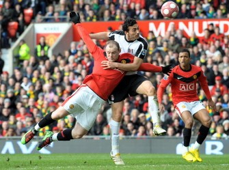 Wayne Rooney (L) vies with Fulham's Irish defender Stephen Kelly during the English Premier League football match at Old Trafford in Manchester on March 14, 2010. AFP PHOTO