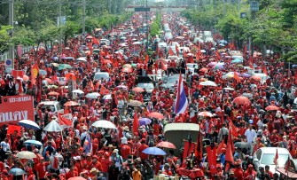 Red-shirted supporters of deposed Thai premier Thaksin Shinawatra wave flags and shout slogans during an anti-government protest outside a military baracks in Bangkok on March 15, 2010. AFP photo