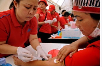 An unidentified Thai woman donates her blood Tuesday, March 16, 2010, at an anti-government rally in Bangkok, Thailand.