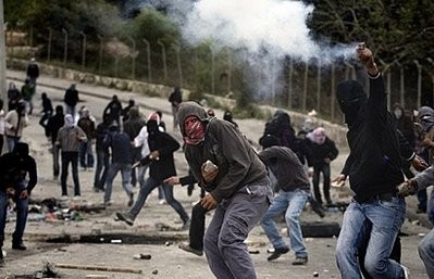 Masked Palestinian demonstrators hurl stones as they clash with Israeli police in East Jerusalem.