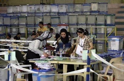 Electoral workers sort through ballots cast at a counting center in Baghdad, Iraq, Sunday, March 14, 2010