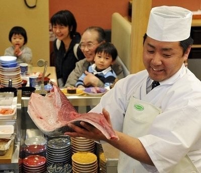 In a picture taken on March 12 a sushi chef holds up bluefin tuna fillet at a sushi restaurant in Yokohama city, suburban Tokyo.
