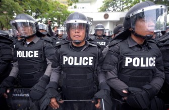 Thai riot policemen stand guard as supporters of deposed Thai premier Thaksin Shinawatra protest at the US embassy in Bangkok on March 17, 2010. AFP photo