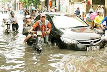 This undated file photo shows Ho Chi Minh City residents trek through a flooded street (Photo: SGGP)