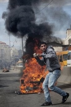 (AFP file) A Palestinian throws stones at Israeli soldiers during clashes in the West Bank town of Qalandia