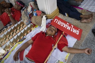 A red-shirted protestor rests in the early morning in Bangkok on March 19, 2010. AFP photo
