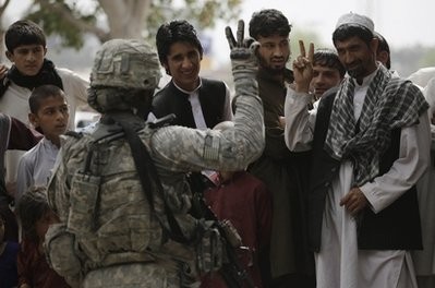 Sgt. Kevin Garcia of Colorado Springs, Colorado,. tries to teach the peace sign to Afghans while patrolling with the 4th Brigade Special Troops Battalion Monday, March 22, 2010, in Nangarhar province of Afghanistan.
