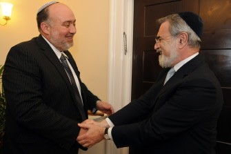 A handout picture obtained on March 23, 2010 from the Embassy of Israel in London shows Israel's ambassador to London, Ron Prossor (L) shaking hands with Chief Rabbi Jonathan Sacks during a housewarming reception at the Israeli Embassy's newly refurbished premises in London. AFP photo