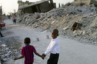 Youths walk through a street lined with rubble from buildings that collapsed in the earthquake in the Fort Nationale neighborhood of Port-au-Prince, Wednesday, March 24, 2010. (AFP Photo)