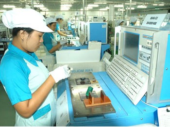 Workers operate producing line at the Japanese NIdec company manufacturing computer assemblies in the High Tech Park in Ho Chi minh City