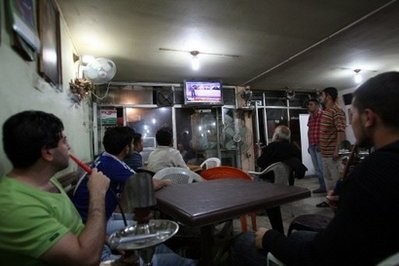 Iraqis follow the announcement of the official results of the general election on TV at a cafe in Baghdad