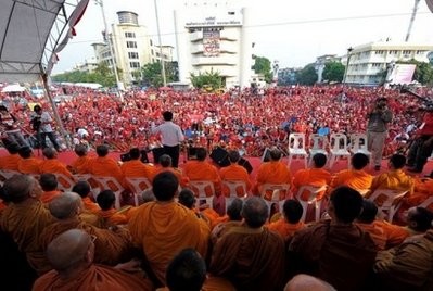 Buddhist monks sit on a stage as Red Shirt protesters (in background), supporters of ousted Thai premier Thaksin Shinawatra, gather for an anti-government protest in Bangkok, on March 27