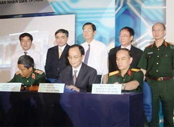 HCMC Department of Information and Communications director Le Manh Ha (C) signs an agreement with representatives of the Military Scientific and Technology Institute and the Ho Chi Minh Mausoleum Safeguarding High Command on applying advanced IT technology to safeguard the mausoleum (Photo: The Gioi Vi Tinh)