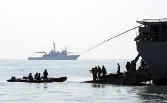 South Korean Navy Ship Salvage Unit members launch rubber boats from Landing Ship Tank LST-685 Seonginbong to search for possible survivors and bodies on March 29, 2010. AFP photo