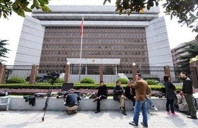 Security personel sit among waiting journalists outside the Shanghai No.1 Intermediate People's Court. AFP photo
