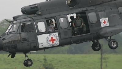 A delegate of the International Red Cross waves from a Brazilian military helicopter taking of from an airport in Florencia, Colombia, to pick up rebel hostage Pablo Moncayo, Tuesday, March 30, 2010.