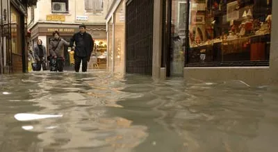 Khách du lịch lội nước trong khu vực mua sắm ở Venice