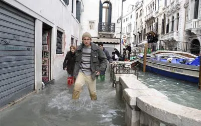 Lội bộ trong nước ngay cạnh một cây cầu trên kênh đào ở Venice