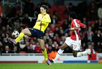 Tiền đạo Zlatan Ibrahimovic (áo vàng) ghi cả hai bàn thắng cho Barcelona, trong pha đi bóng trước Alex Song của Arsenal.