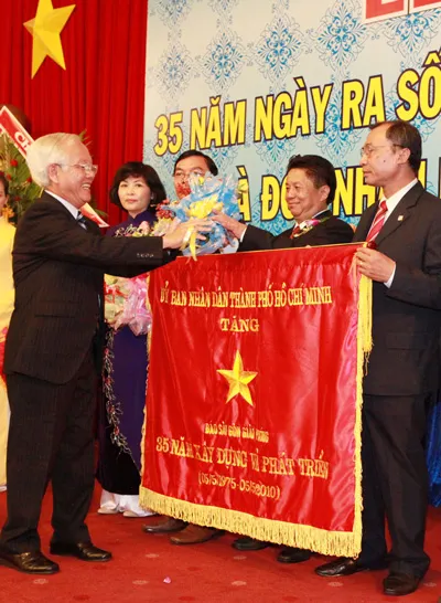 Chủ tịch UBND TP Lê Hoàng Quân tặng cờ truyền thống cho Ban biên tập Báo SGGP. Ảnh: Trần Thanh