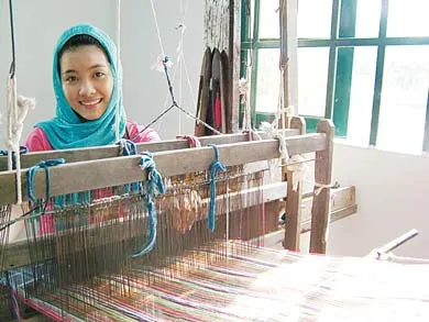 Du khách đóng vai cô gái Chăm bên khung dệt thổ cẩm.