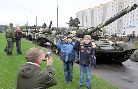 Thiếu nhi tại Kyrgyzstan chụp hình bên những chiếc xe tăng trong lễ duyệt binh Ngày Chiến thắng