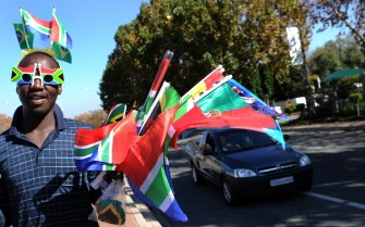 Recent picture showing a street vendor wearing the South African flag sun glasses sells flags in Johannesburg on May 14, 2010 of the 32 countries taking part in the FIFA World Cup. AFP photo