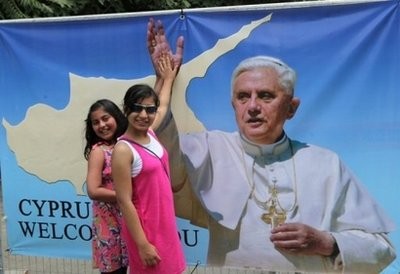 Children have their photo taken in front of a huge poster of Pope Benedict XVI in Nicosia. AFP photo