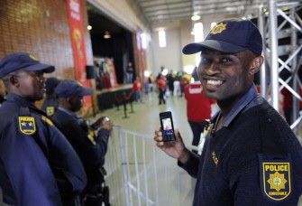 A South African policeman shows the photo he took with his cellular phone of the FIFA World Cup trophy exhibited at the Diamini Centre in Soweto on June 4, 2010. AFP photo