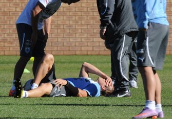 Diego Forlan holds his left thigh after colliding with a teammate during a training session at the GWK Park stadium in Kimberley on June 6, 2010. AFP photo