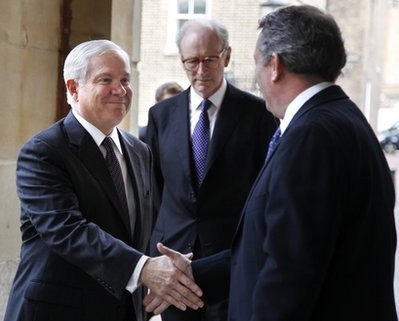 Defense Secretary Robert Gates, left, is greeted by British Defense Secretary Liam Fox, right, in London, Tuesday, June 8, 2010. At center is protocol officer Mark Corbet Burcher