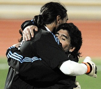 Diego Maradona (R) embraces Argentina's goalkeeper Sergio Romero during a team training session at the University's High Performance Centre in Pretoria on June 9, 2010. AFP photo