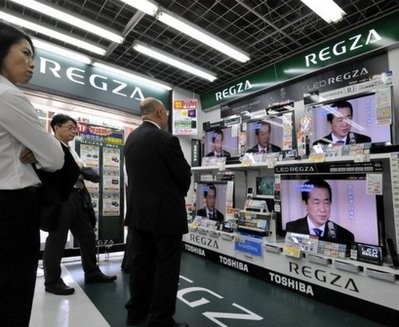 Businessmen watch televisions as Japan's new prime minister Naoto Kan gives a speech. AFP photo