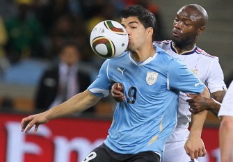 Uruguay's striker Luis Suarez (L) is hit by the ball in front of France's defender William Gallas on June 11, 2010. AFP photo