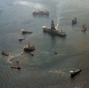The Transocean Discoverer Enterprise drill ship (with flare) collects oil from the site of the BP Deepwater Horizon oil well disaster