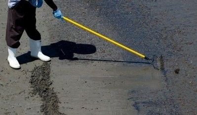A worker collects oiled sand hit by the BP Deepwater Horizon oil spill from the Gulf of Mexico as cleanup crews work to clean the beach at Grand Isle State. AFP photo