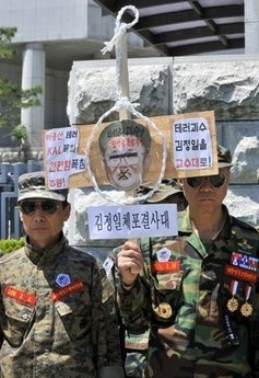 South Korean veterans hold a mock gallows along with a portrait of North Korean leader Kim Jong-Il during a rally in Seoul on June 1, 2010
