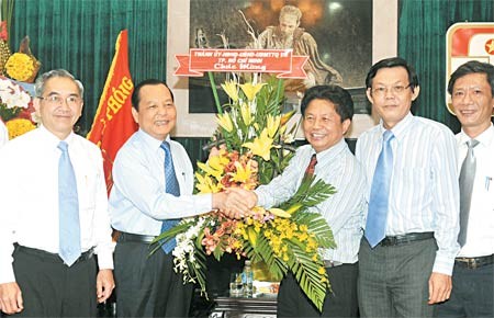 Secretary of the Ho Chi Minh City Party Committee Le Thanh Hai (2nd, L) gives flowers to Sai Gon Giai Phong editor-in-chief Tran The Tuyen (3rd, R) on his visit to the newspaper on June 18 in celebration of Vietnam's 85th Revolutionary Journalism Day (June 21), ( Photo SGGP )