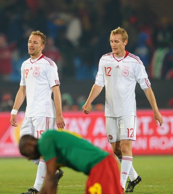Cameroon's defender Stephane Mbia (down) kneels on the field as Denmark's striker Dennis Rommedahl (L) and Denmark's midfielder Thomas Kahlenberg walk past on June 19, 2010 at Loftus Verfeld stadium in Tshwane/Pretoria. AFP