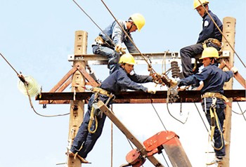 Workers install electric cables in the Mekong Delta city of Can Tho (File photo: SGGP)
