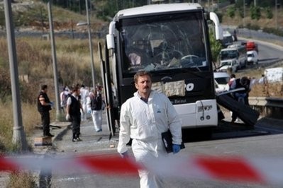 Policemen and officials inspect the wreckage of a military bus that following a roadside bomb blast in Istanbul. AFP