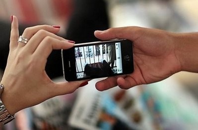 Customers check out the new Apple iPhone 4 as they wait in line to buy their own at an Apple Store in Miami Beach, Florida. AFP
