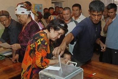 People cast their ballot papers into mobile voting box in the southern Kyrgyz city of Osh, Kyrgyzstan, Sunday, June 27, 2010 during a referendum on a new constitution.
