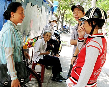 Ms. Nguyen Thi Ngoc Hanh (L) propagandizes for people effective methods to lessen the rates sexual transmitted diseases and drug use. (Photo : Sggp)